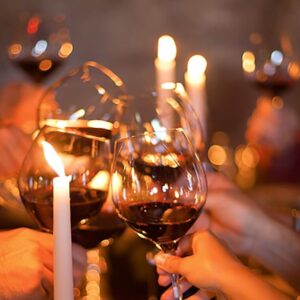 photo of hands clinking wine glasses